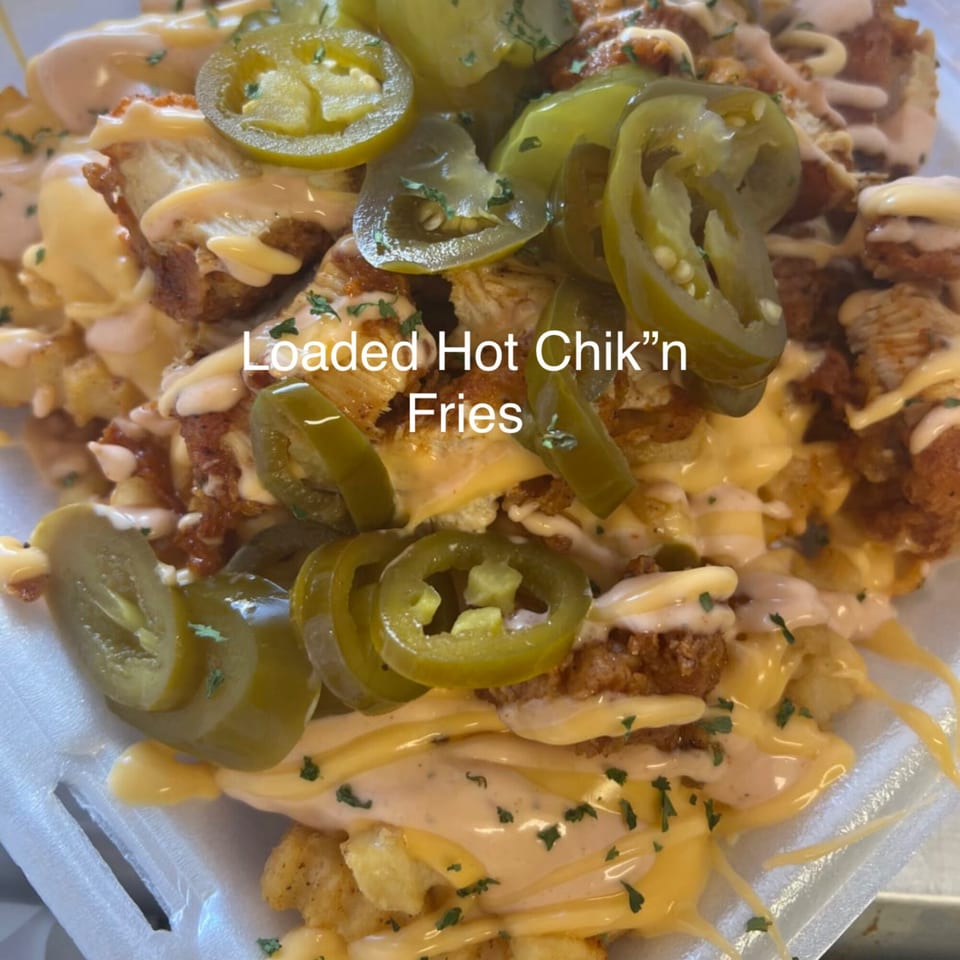 Loaded Hot Chik'n Fries from Vaqueros Over the Fire, topped with cheese, sauce, and jalapeños.